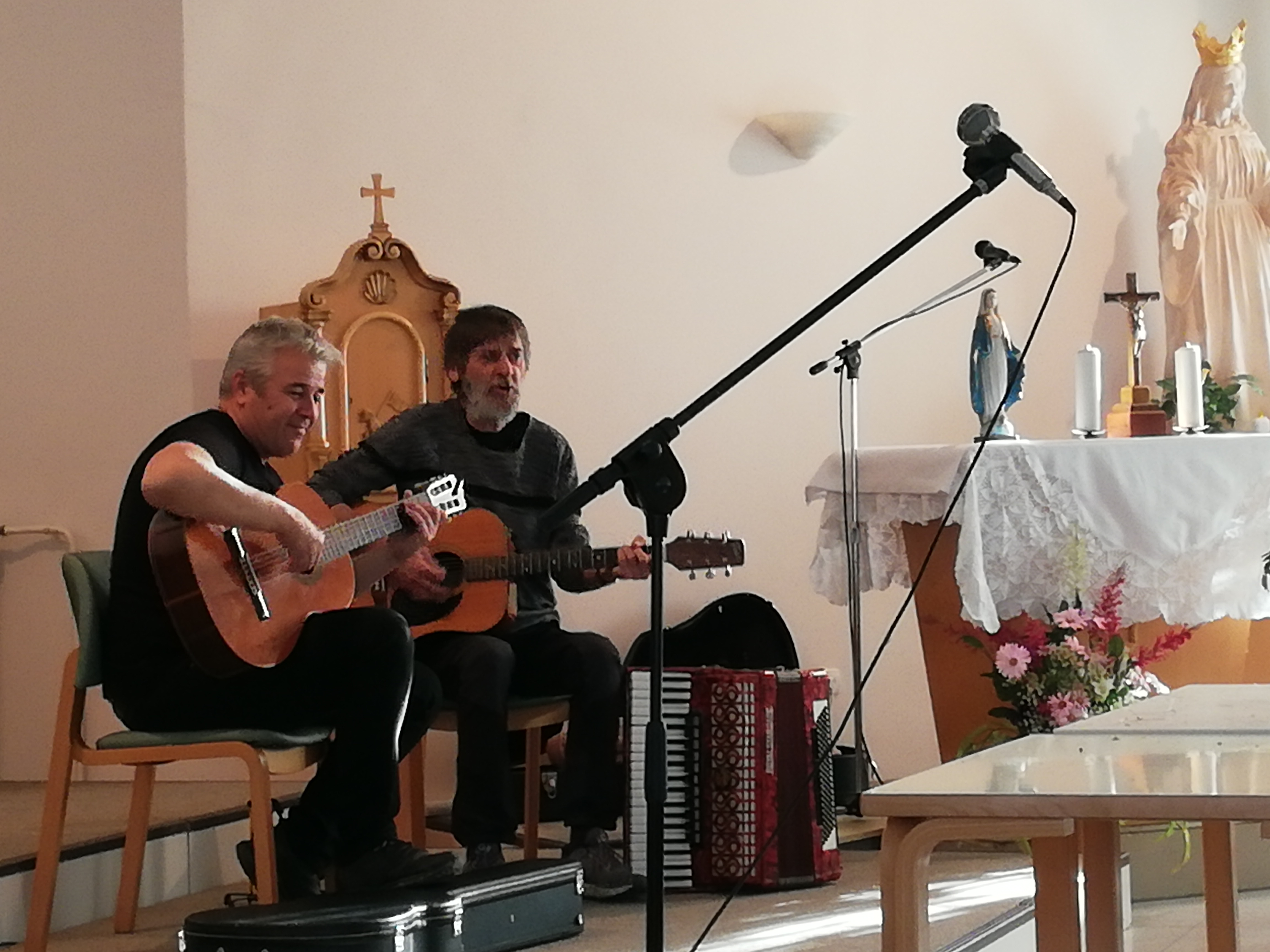 Levo Marko Fujan s kitaro in Brane Bičanič s kitaro igrata in pojeta pesmi o rožah. 